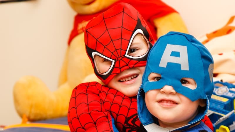 Kinderhypnose in Hamburg lässt Kinder zu Superhelden werden. Zwei Kinder in Kostümen. Spidermann un der Mitte und Captain America im Vordergrund. Im Hintergrund ist ein Teddybär zu erkennen.